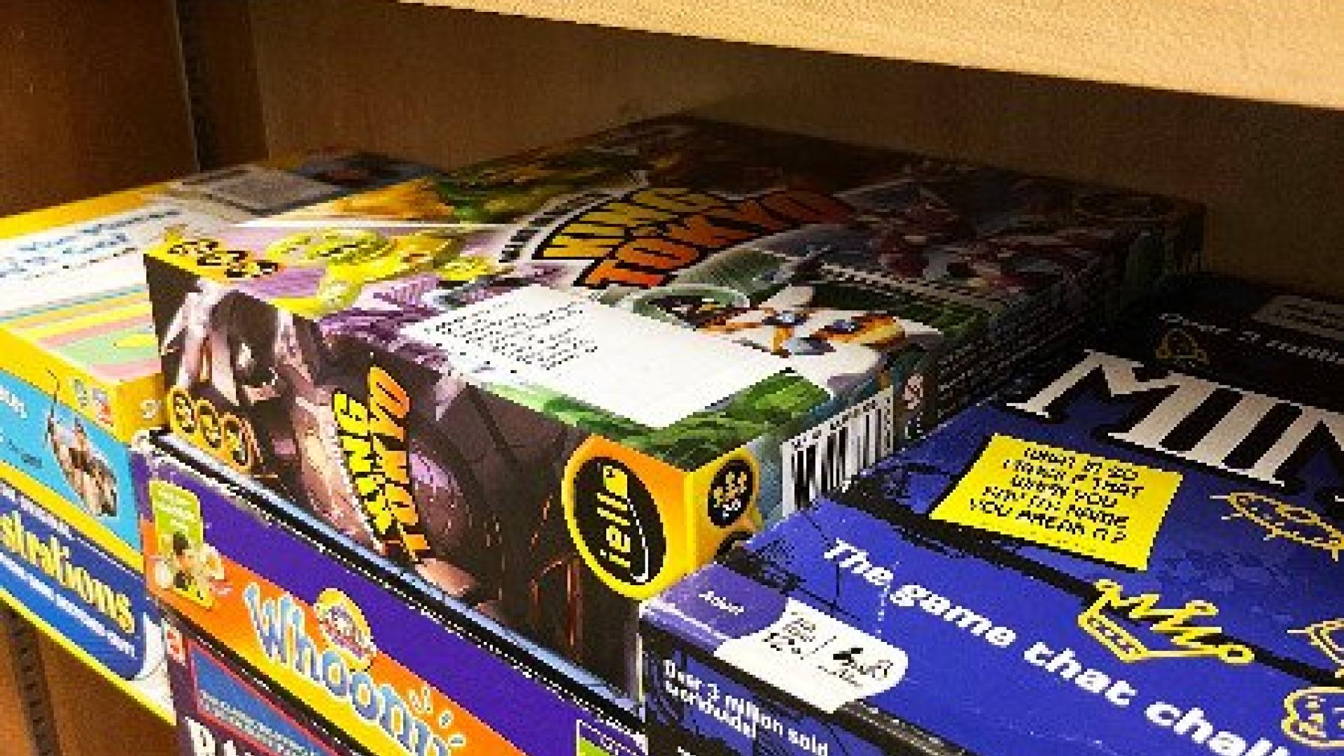 Several board games stacked on a shelf
