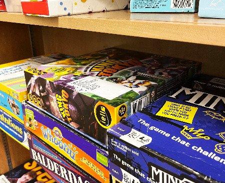 Several board games stacked on a shelf